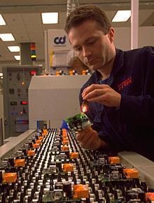 A technician inspects some of the plant's output of air bag crash sensors that are marketed to European automotive customers.